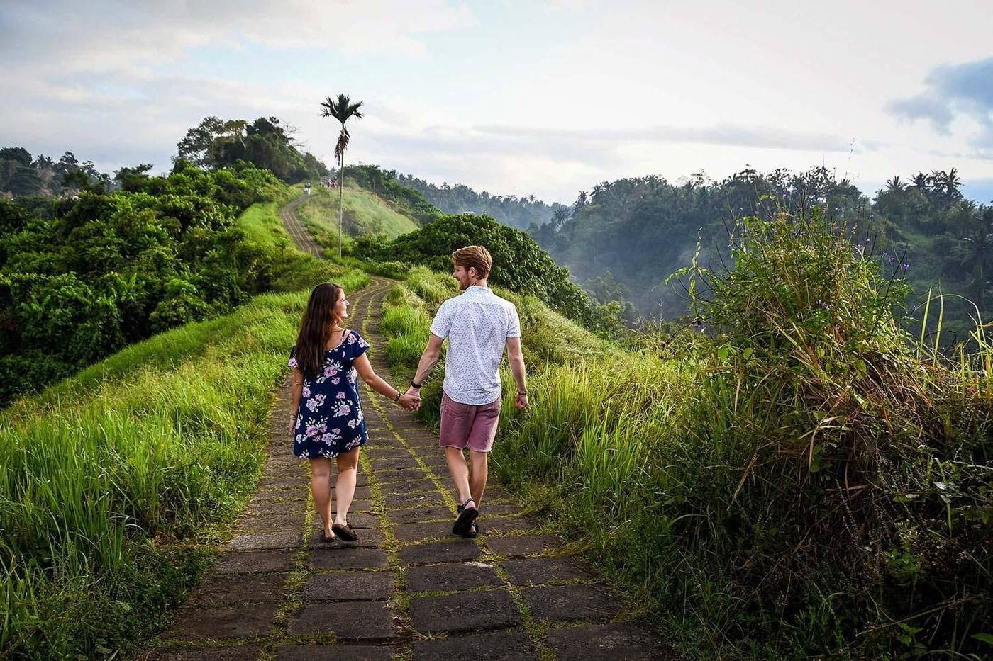 Couple walking through green rice terraces in Bali